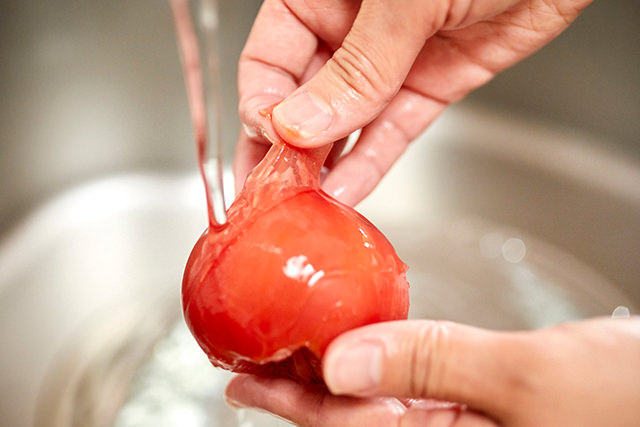 冷凍トマトの皮をむいている写真