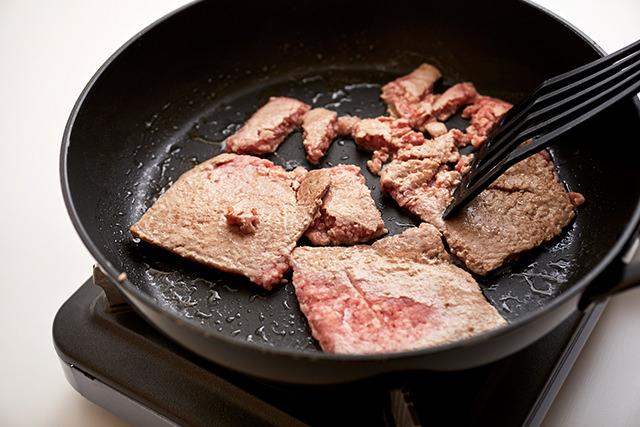 凍った豚挽き肉を炒めている写真