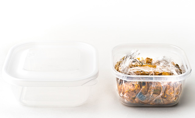 密閉容器とラップをかけてカレーを入れた密閉容器の写真