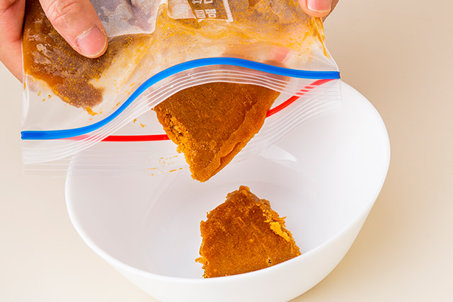 保存袋で冷凍したカレーを耐熱皿に移している写真