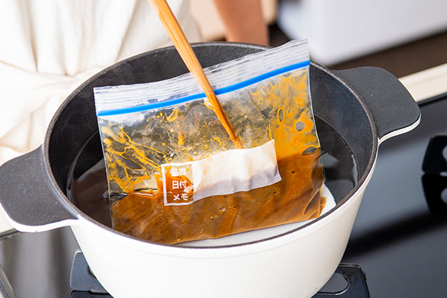 冷凍したカレーを菜箸でおさえている写真