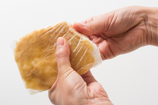 板状に冷凍した生姜をパキッと折っている写真