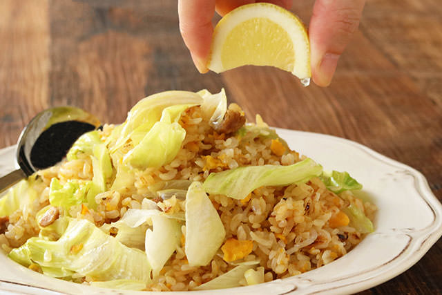 冷凍炒飯にレモンを絞っている写真