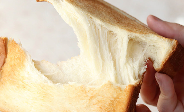 焼きあがった食パンを手で割っている写真