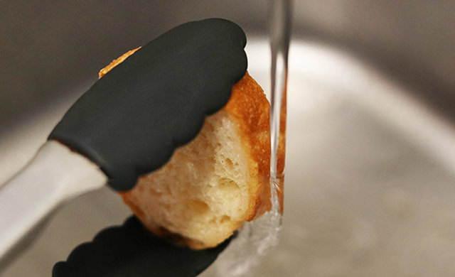 バゲットを水道水に直接くぐらせている写真