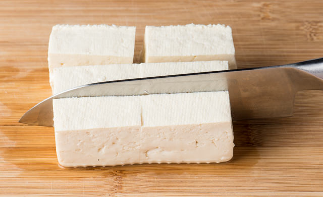 豆腐を包丁で2～3cmｘ4～5cmに切っている写真