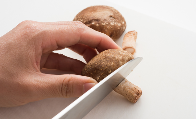 しいたけのかさと軸を切り分けている写真