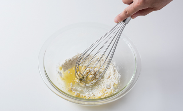 バターと薄力粉を泡だて器で混ぜている写真