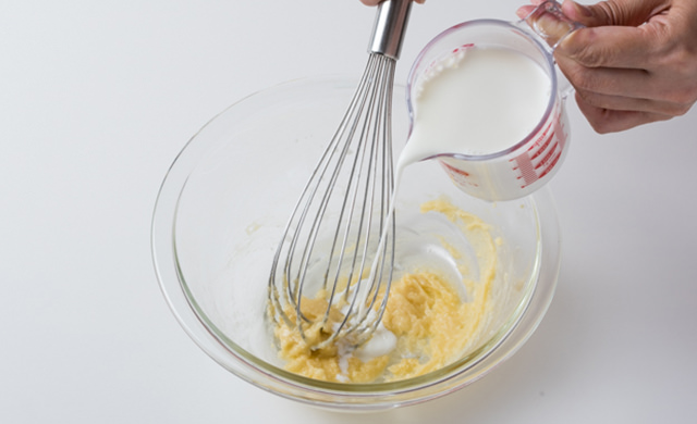 ボウルに牛乳を少しずつ入れている写真