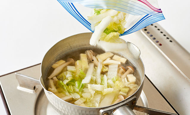 白菜を味噌汁に加えている写真