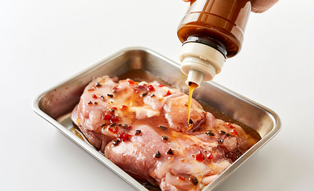 鶏肉にドレッシングをかけている写真