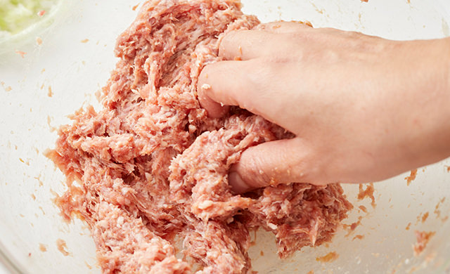 挽き肉と調味料を混ぜている写真