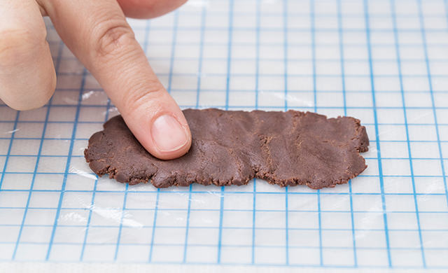 指で押さえて口パーツの生地をある程度伸ばす