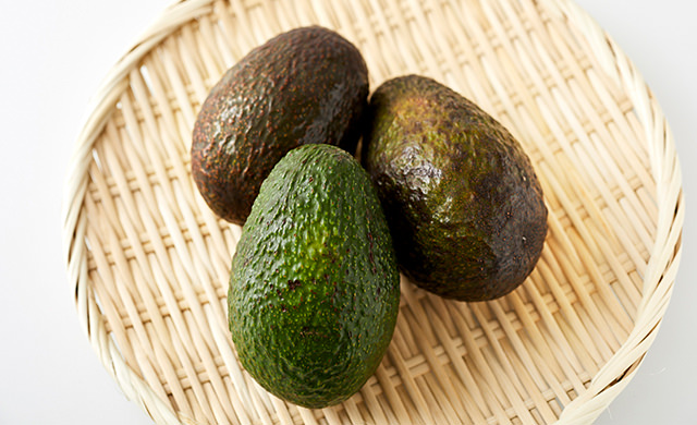 ざるに入れたアボカドの写真