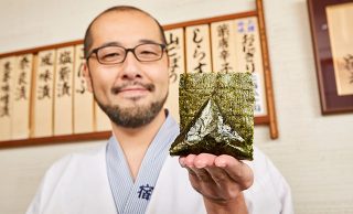 おにぎりを手にする店主の写真A