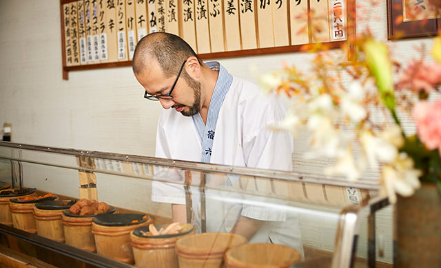 カウンターでおにぎりを握る三浦さんの写真