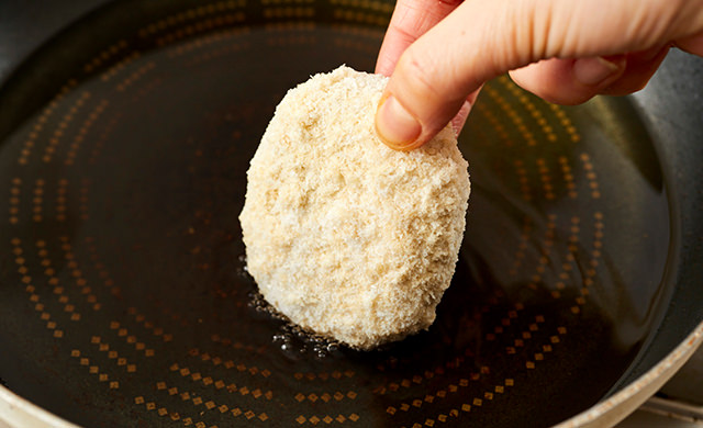 冷凍コロッケを油に入れる写真