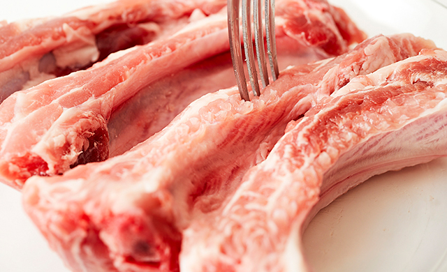 スペアリブをフォークで刺す写真