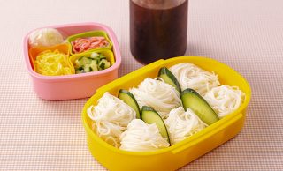 ひと口サイズに丸めて薄切りきゅうりで仕切ったそうめん弁当、トッピ ング具材を入れた容器、つゆを入れた容器を組み合わせた写真