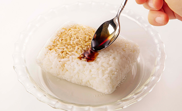 冷凍ごはんにスプーンで醤油をかけている写真