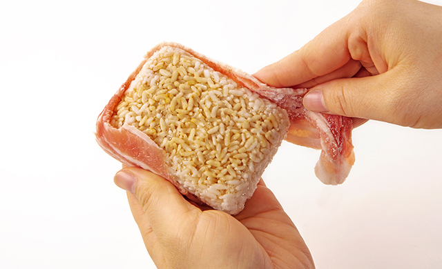 冷凍ごはんの側面に豚バラ薄切り肉を巻きつけている写真