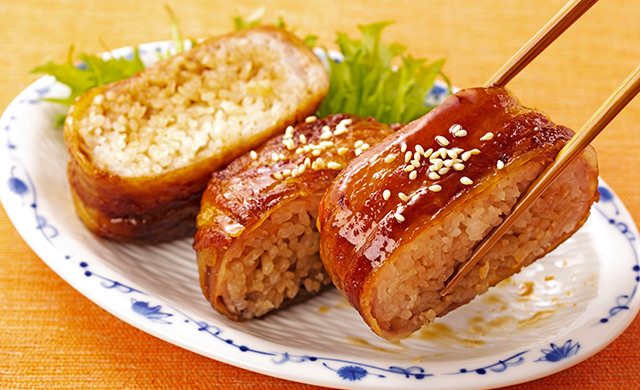 肉巻きおにぎりを箸で持ち上げている写真