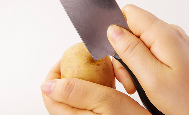 じゃがいもの芽の周りに包丁のあご（刃元の角）をさし、芽をえぐり取っている写真
