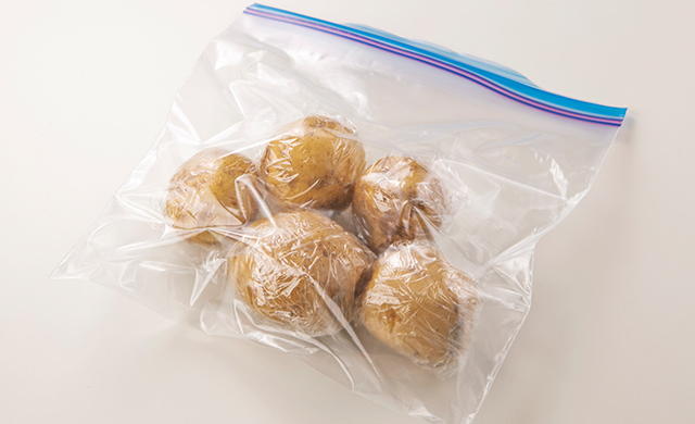 １個ずつ丸ごとラップに包んで冷凍用保存袋に入れたじゃがいもの写真