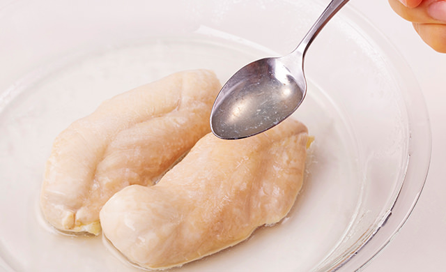 レンジで加熱したときにささみ肉から出た汁をスプーンですくっている写真