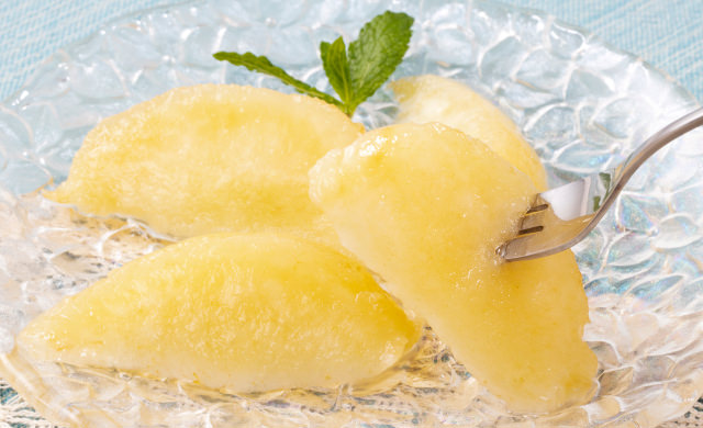 半解凍した桃にフォークをさして持ち上げた写真