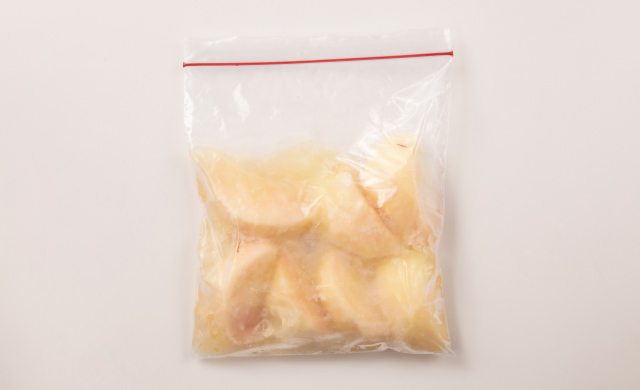 冷凍用保存袋に入れたりんごジュース漬け冷凍桃の写真