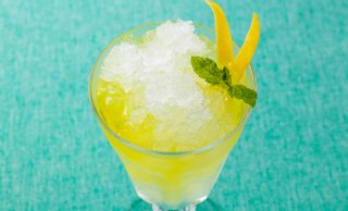 冷凍した焼酎に炭酸水とレモンの皮を焼酎につけたリモンチェッロを入れ、レモンの皮とミントをトッピングした写真