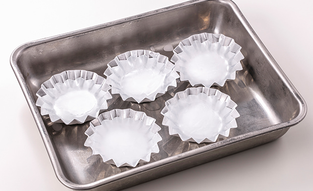 アルミカップを金属バットの上に並べて氷を作っている写真