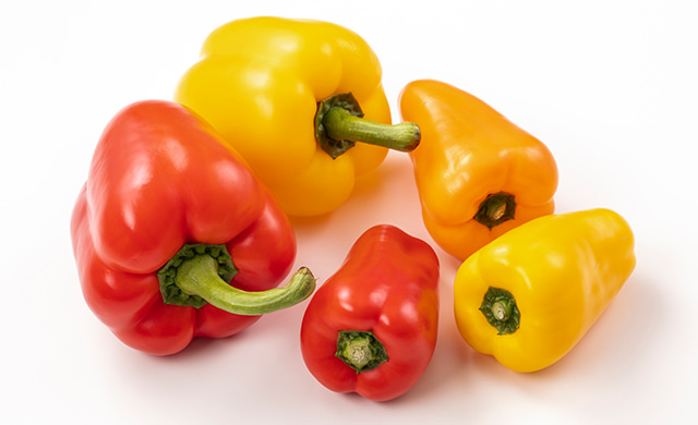 赤、黄のパプリカ（左）と赤、黄、オレンジのカラーピーマン（右）の写真