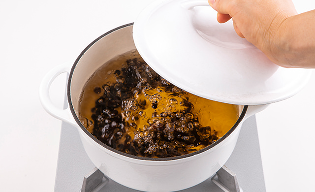 タピオカをゆでている鍋の蓋をしめるところの写真