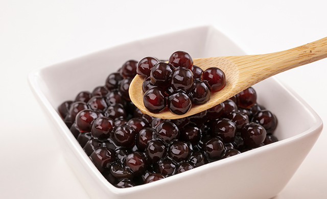 タピオカをゆでている鍋の蓋をしめるところの写真