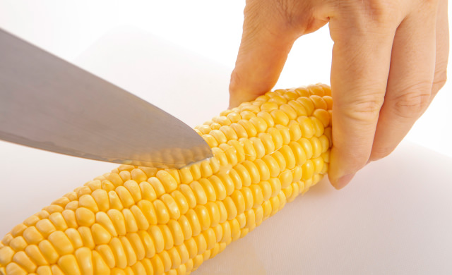 とうもろこしの実に切れ目を入れている写真