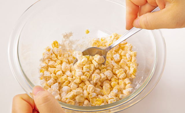 とうもろこしと薄力粉を絡めている写真