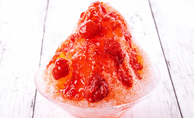 果肉ごろごろいちごをかけたかき氷の皿盛り写真