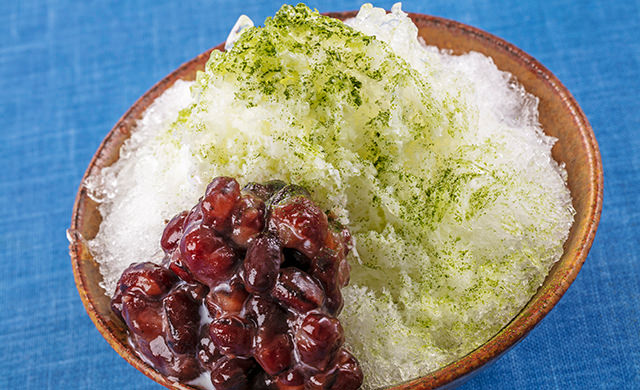 抹茶ミルクあずきをかけたかき氷の皿盛り写真