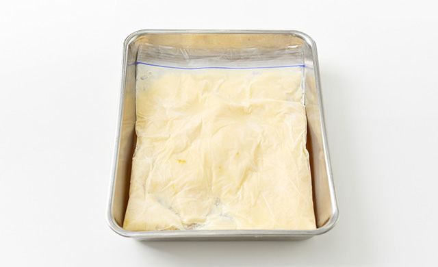 材料が入った冷凍用保存袋を平らにして金属製バットに置き、冷凍庫で1時間半～2時間冷凍した写真