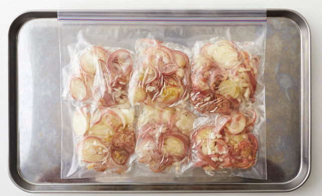 小口切りにしたみょうがを小分けにしてラップで包み、冷凍用保存袋に入れ、金属製バットにのせている写真