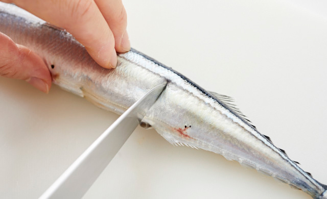 さんまの腹部分に切れ込みを入れている写真