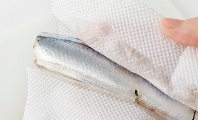 さんまの身をキッチンペーパーで拭いている写真