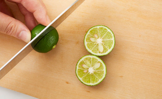 まな板の上で、すだちを横半分に切っている写真