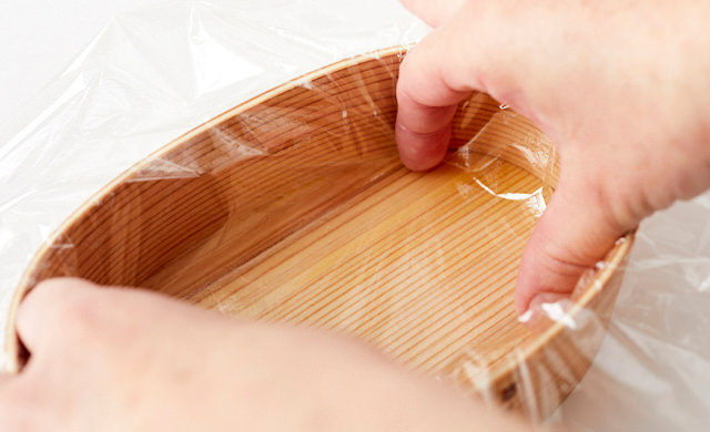 お弁当箱の内側に沿ってラップを敷き詰める写真