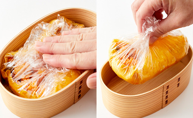 お弁当箱の中でラップで薄焼き卵とケチャップライスを密着させている写真/ラップごとオムライスを弁当箱から出す写真