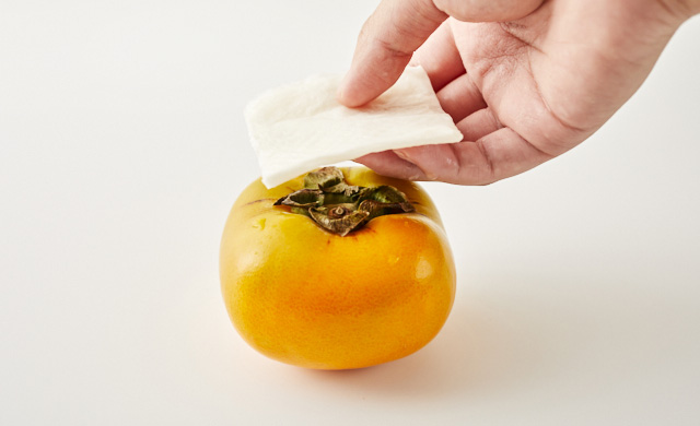 柿にキッチンペーパーを被せている写真