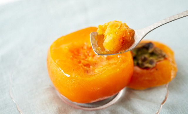 丸ごと冷凍した柿をスプーンですくっている写真