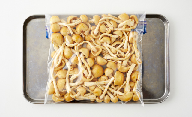 バラバラにしたなめこを冷凍用保存袋に入れ金属製のバットにのせた写真